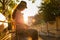 Woman stroking a homeless cute ginger cats on the street. Sunset light. Side view. Animal protection and adoption concept