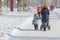 A woman with a stroller in the city in the winter. Mom walks with a child in the winter.