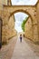 Woman strolling through the old medieval city with stone arches, Zamora Spain.