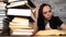 Woman student boring reading book at library with a lot of books in university.