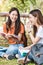 Woman students and girlfriend are during sitting reading books outdoor