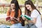 Woman students and girlfriend are during sitting reading books outdoor