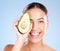 Woman, studio portrait and avocado skincare with smile, health or wellness by blue background. Model, fruit and face