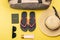 Woman stuff such as luggage bag, hat, slippers, lotion, sunglasses and passport for traveling