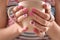 Woman with stylish color nails holding mug, closeup