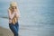 Woman in stylish outfit feeling cold by the sea