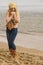 Woman in stylish outfit feeling cold by the sea