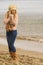 Woman in stylish outfit feeling cold by the sea