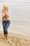 Woman in stylish outfit feeling cold by the sea