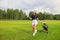 Woman in stylish summer golf outfit walking with bag of drivers for golf game.