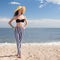 Woman in stylish swimsuit on beach