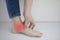 Woman suffering from heel pain. Inflammation or sprain of the tendon in the foot, heel spur, bursitis. The concept of diseases and