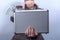 Woman in suit holds metal briefcase with dollars