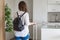 Woman with suitcase in shirt and shorts going to the door and waiting a taxi. ready to trip. Individual traveler.