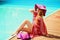 Woman sunbathing in bikini at tropical travel resort. Beautiful young woman lying on sun lounger near pool.