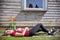 Woman sunbathing on the lawn with orange flowers under a window