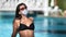 Woman sunbathing near swimming pool wearing protective medical mask. Medium shot on RED camera
