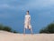 Woman sundress red shoes ax sand nature blue sky
