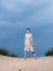 Woman sundress red shoes ax sand nature blue sky