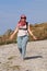 A woman in sunglasses and an arabic headscarf walks along the road under the scorching sun