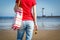 Woman with sunglasses and bag on west breakwater in Swinoujscie by navigational mark Windmill Stawa Mlyny. Vacation and summer