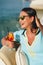 Woman with sunglasses drinking cocktail on a yacht