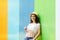 Woman in sunglasses and hat over color background