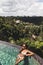 Woman in sunglasses relaxing in luxury infinity pool with jungle view in Ubud