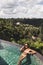 Woman in sunglasses relaxing in luxury infinity pool with jungle view in Ubud