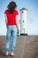 Woman with sunglasses in shape of heart on west breakwater in Swinoujscie. Characteristic navigational mark Windmill Stawa Mlyny.