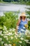 Woman in sunhat picking flowers along lakefront