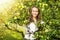 Woman in a sunny apple tree garden during the harvest season. Yo