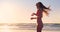Woman, sunset and hair on beach in bikini, happiness and summer break by ocean for relax by seaside. Young person
