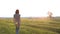 Woman at sunset raises her hands up and enjoys a beautiful warm sunny evening