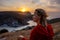 Woman sunset sea mountains. Happy woman siting with her back on the sunset in nature in summer posing with mountains on