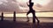 Woman, sunset and silhouette with runner at beach for fitness, speed and action with training for marathon. Athlete
