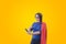 Woman superhero looking at phone with red cape.