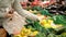 Woman in a supermarket choosing vegetables at the vegetable shelf.