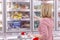 Woman in a supermarket in the frozen food department. Close-up