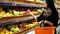 Woman in a supermarket, girl buying apples at grocery