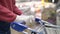 Woman in a supermarket rolls a grocery cart in rubber gloves close-up. Protects against coronavirus.