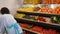 Woman supermarket staff working at store shelves