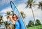 Woman with surf board posing on tropical beach