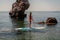 Woman surfboard the sea on a sunny summer day. In a red bathing suit stands with an oar. Summer fun by the sea