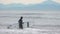 Woman surfer in wetsuit carrying surfboard walking into breaking waves Pacific Ocean to go further into sea on