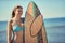 Woman surfers on a beach. Portrait of young women holding a sur