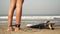 A woman is surfing. A surfer girl on the beach puts a leash on her leg