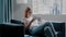 Woman surfs social media on phone sitting on sofa in room