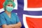 Woman surgeon on the background of the Norway flag. Health care, surgery and medical concept in Norway