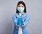 Woman in surgical mask holding a cleaning product